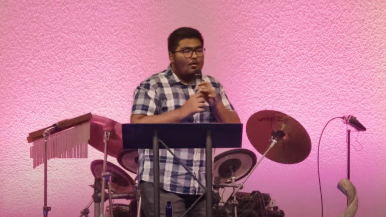 A young Indian man preaches Jesus at New and Living Way Church.